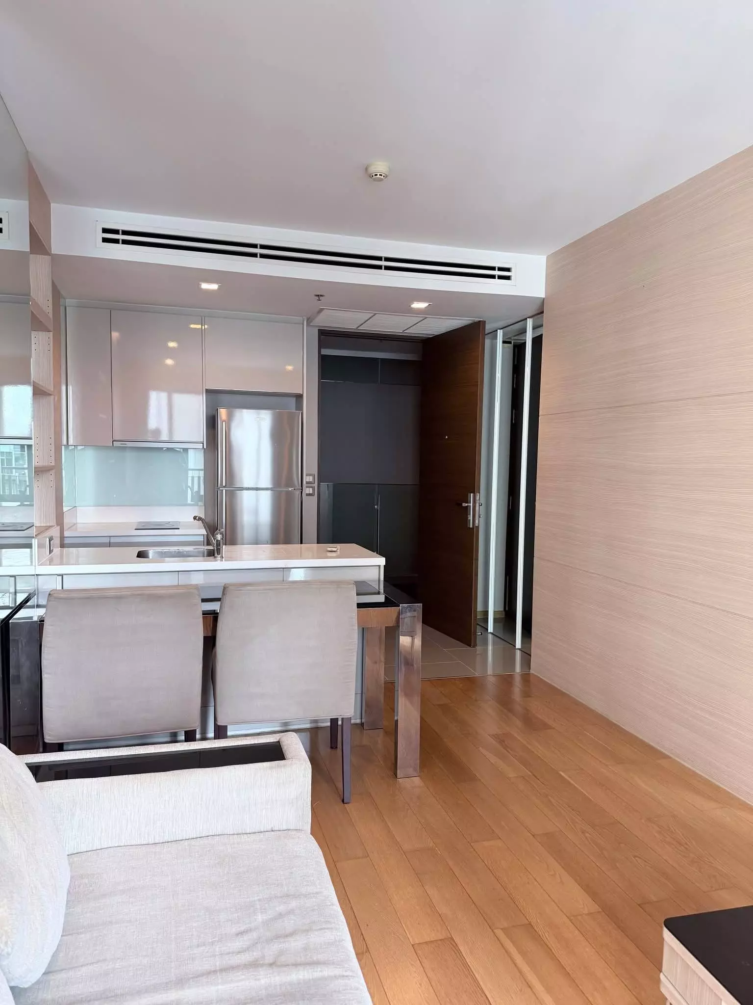 Open-plan living area in a 1-bed condo for sale at The Address Asoke with pink cabinets and quartz island