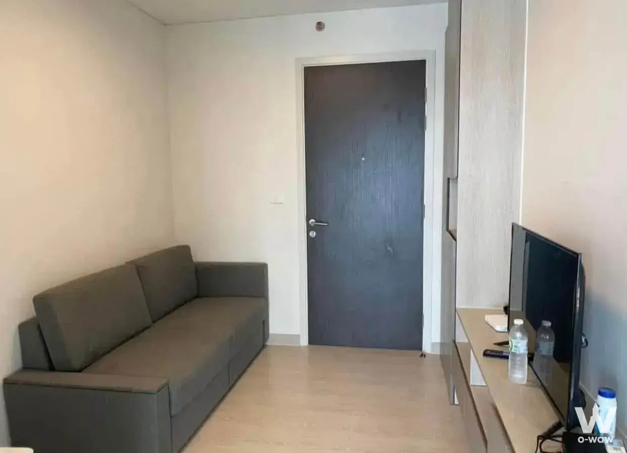 Functional living room in a 1-bed condo for rent at The Station Condo with dark-grey sofa and built-in cabinetry