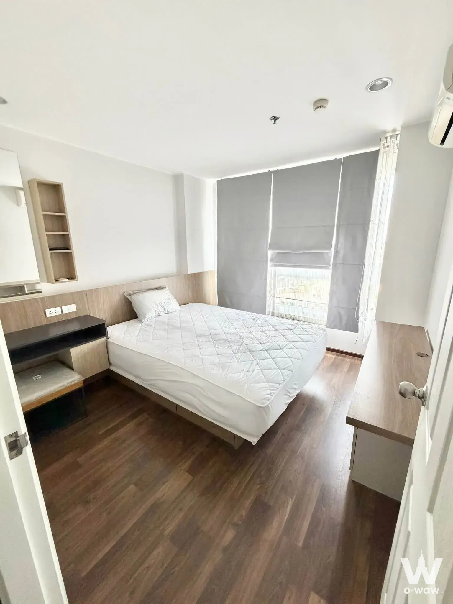 Queen bed bedroom in a U Delight Rachavibha rental featuring light wood headboard and floating desk
