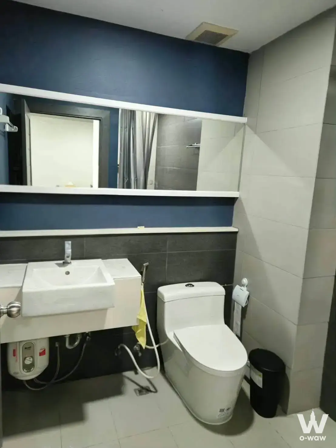 Compact bathroom in The Gallery Bearing featuring navy walls, white vanity, and grey tile flooring