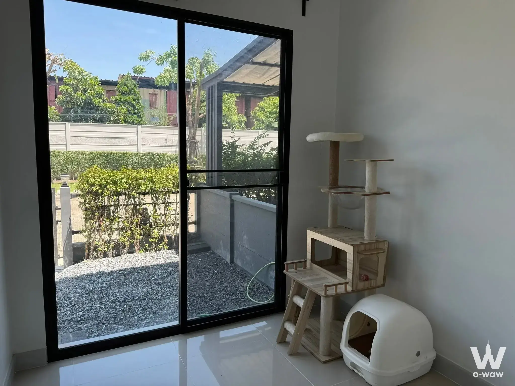 Bright pet area in Pleno Bangyai 2 townhouse featuring a wooden cat tree near a glass door