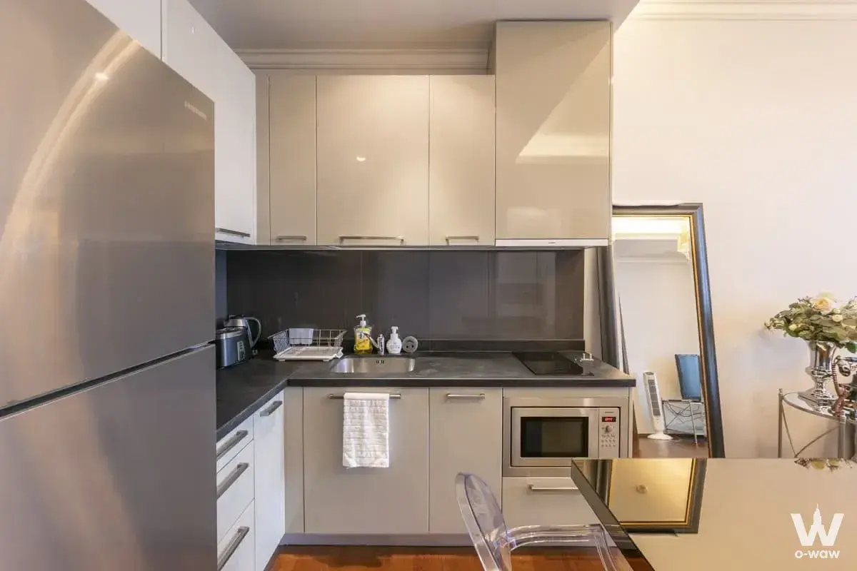 Fully equipped kitchen in Quattro by Sansiri with beige cabinets, stone counters, and a steel fridge