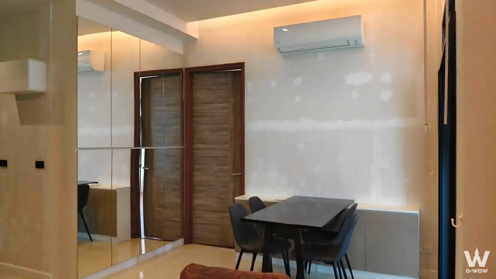 Mayfair Place Sukhumvit 50 dining area with dark table, mirrored wardrobe, and warm LED lighting