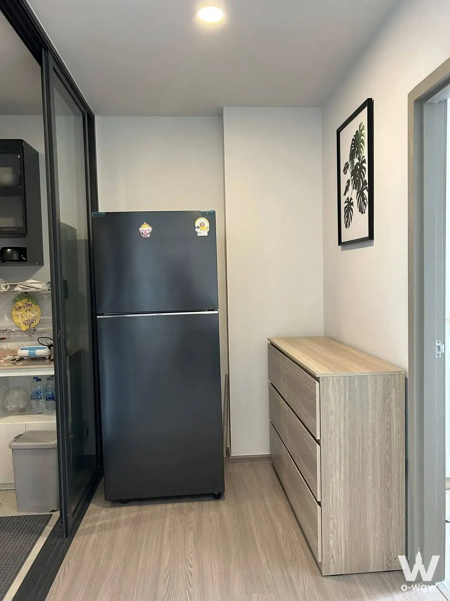 Modern 2-bed condo entryway in Aspire Sukhumvit-Rama 4 with wood flooring and glass kitchen partition