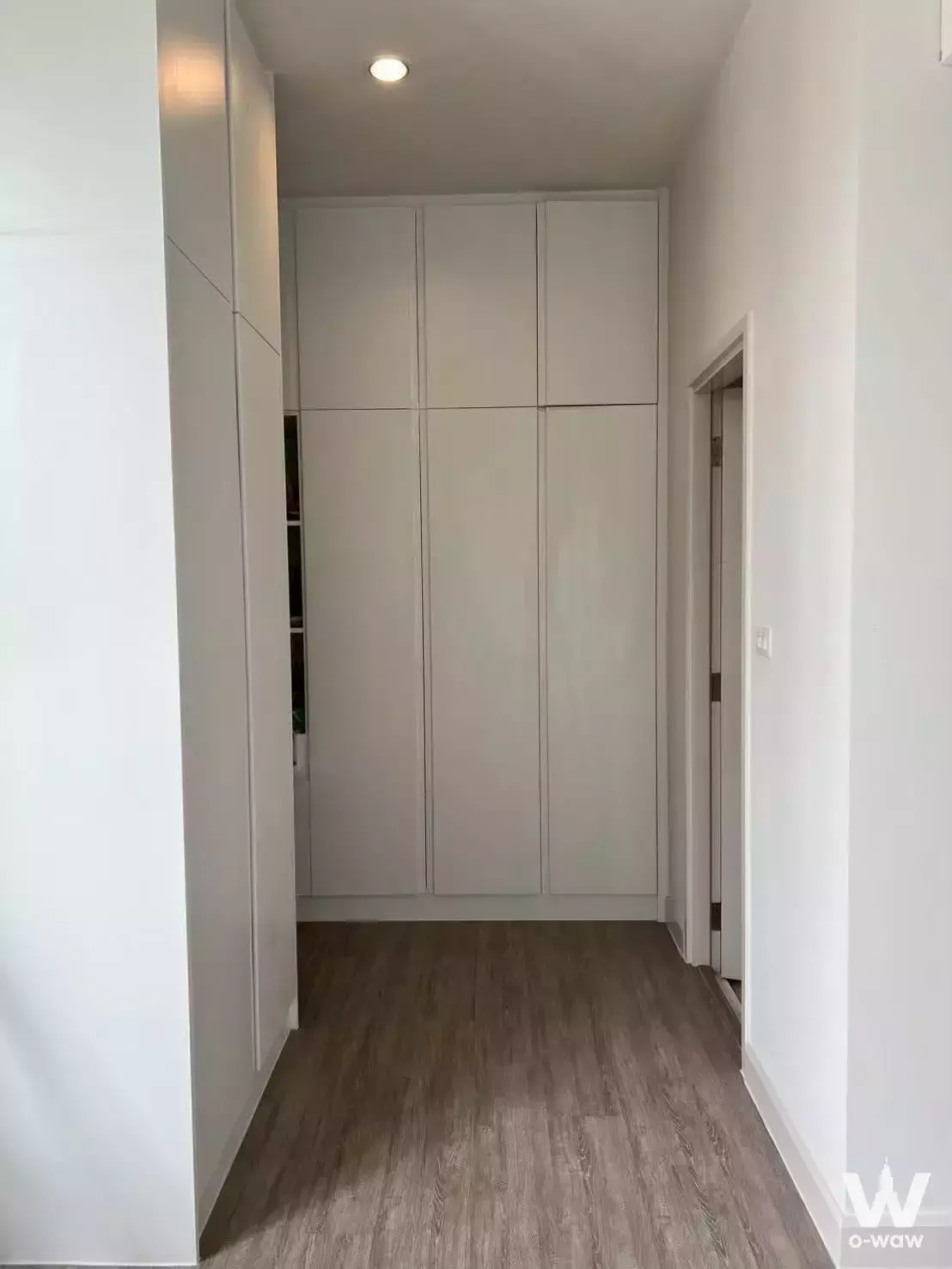 Narrow hallway with floor-to-ceiling white built-in wardrobes in Saransiri Westgate condo