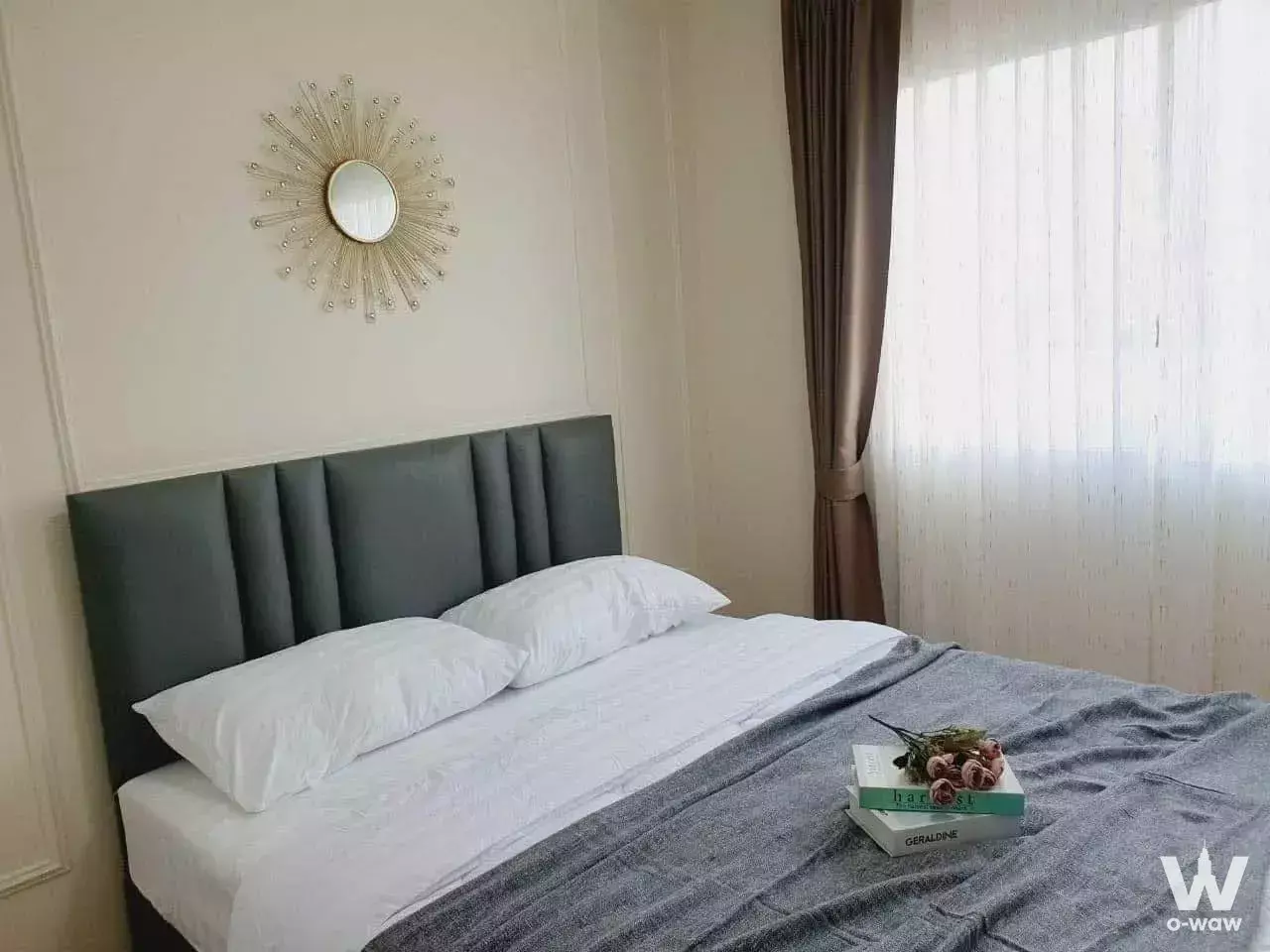 Smart Condo RAMA II bedroom featuring a gold sunburst mirror and neutral staged decor