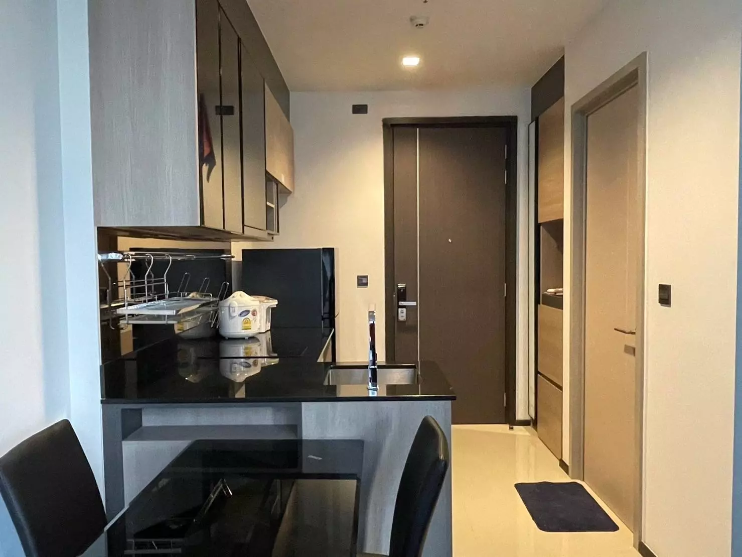Kitchenette in THE LINE Asoke-Ratchada condo with black granite counter and dining set