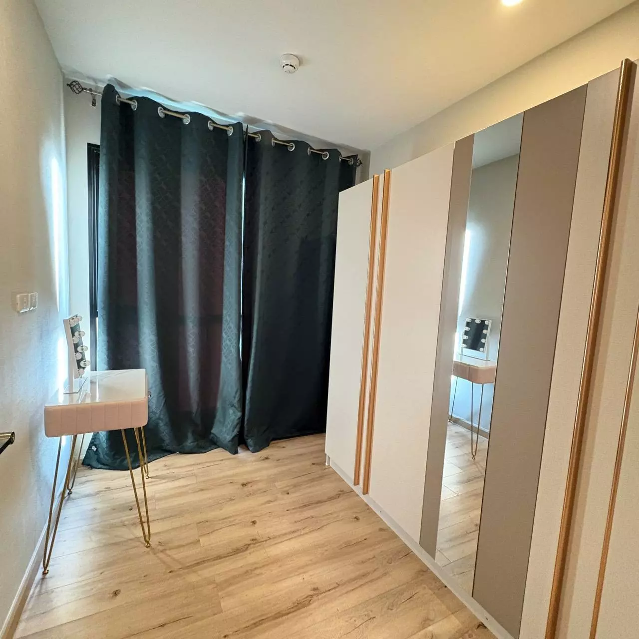 Brix Condominium Charan 64 bedroom featuring wardrobe with gold handles and vanity table