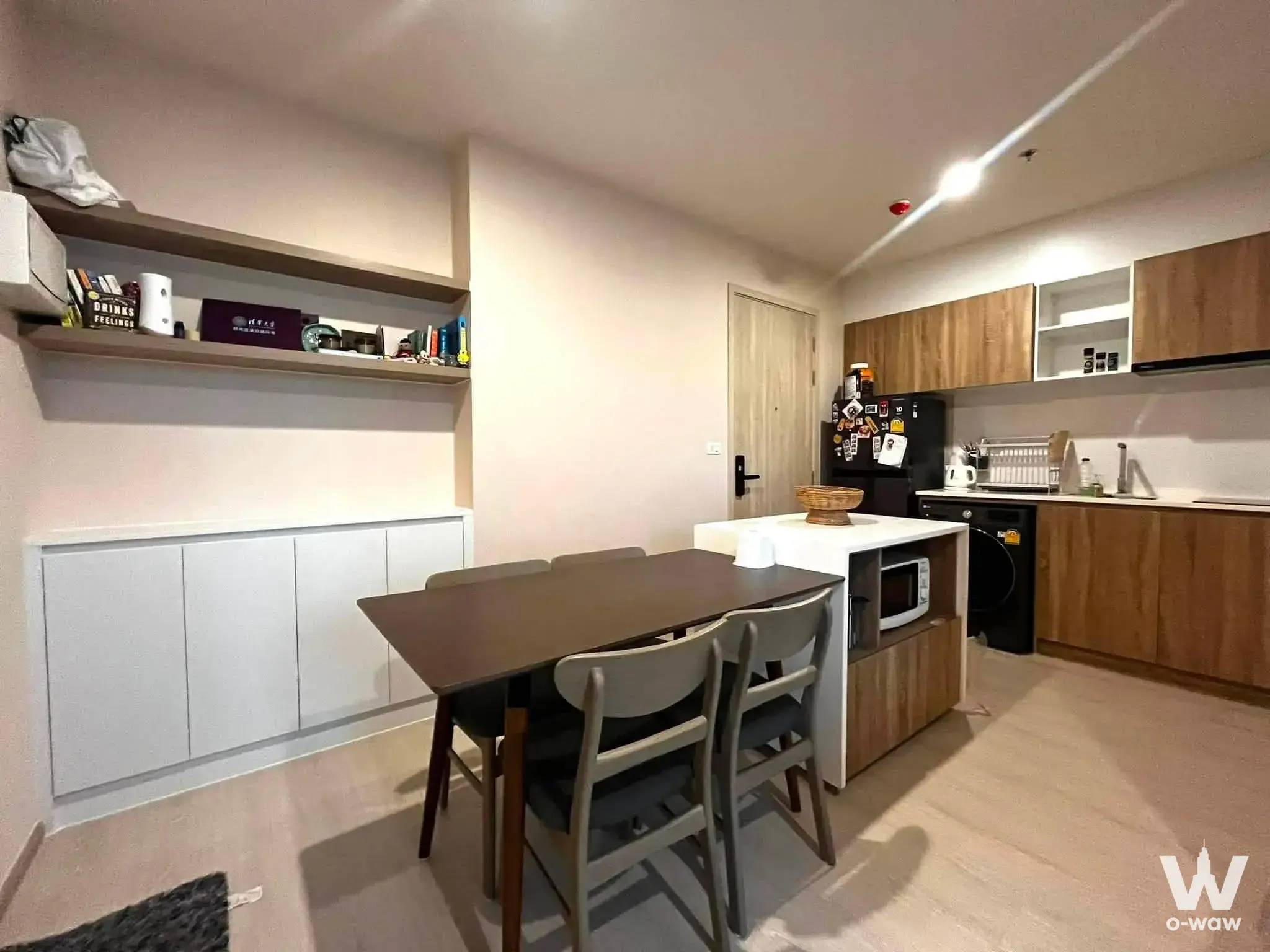 2-bed condo kitchen dining area at NUE Noble Faichai with wood floors and white island