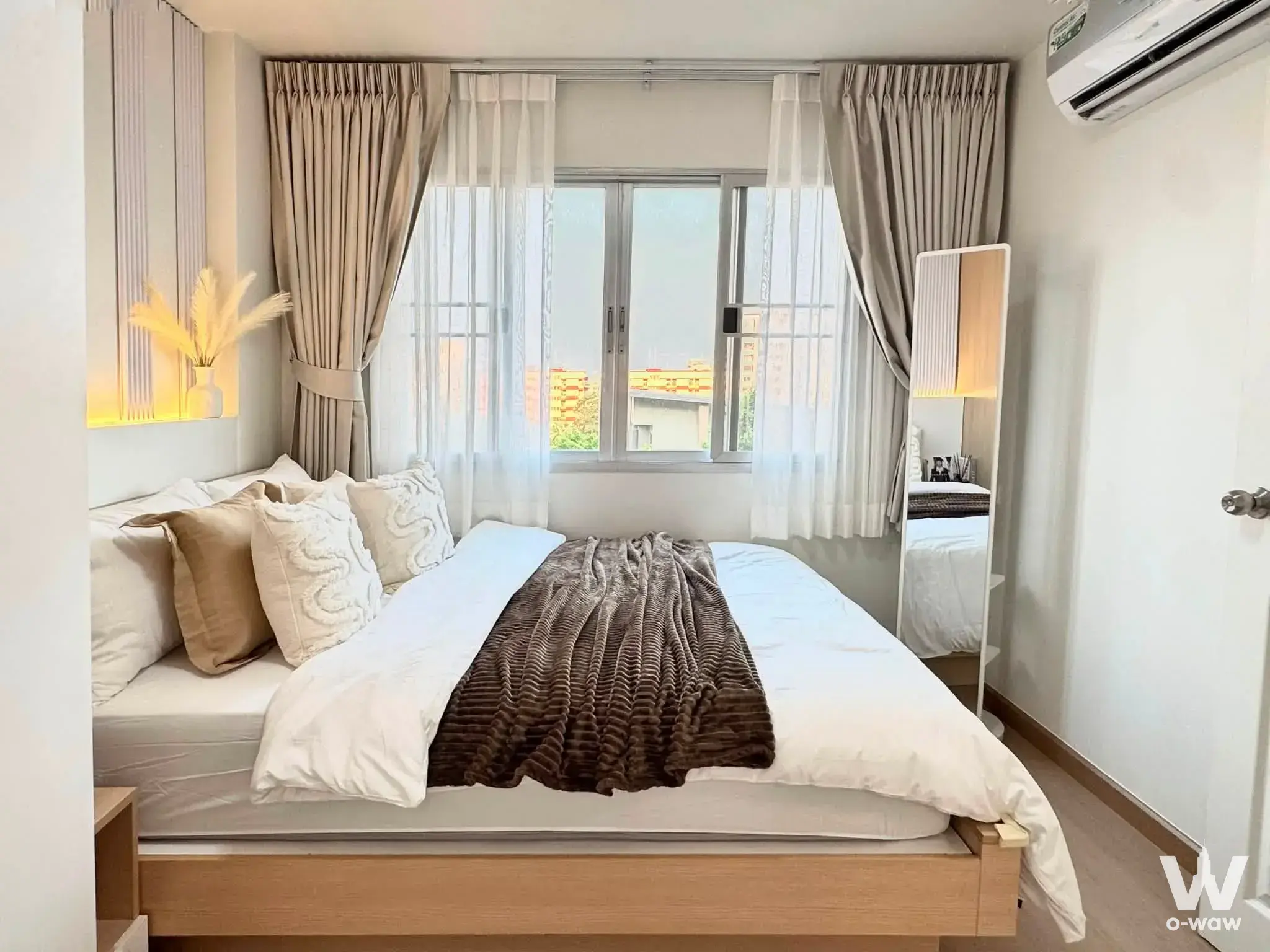 Furnished bedroom in a Lumpini Condo Town Bodindecha-Ramkhamhaeng condo with platform bed and large window