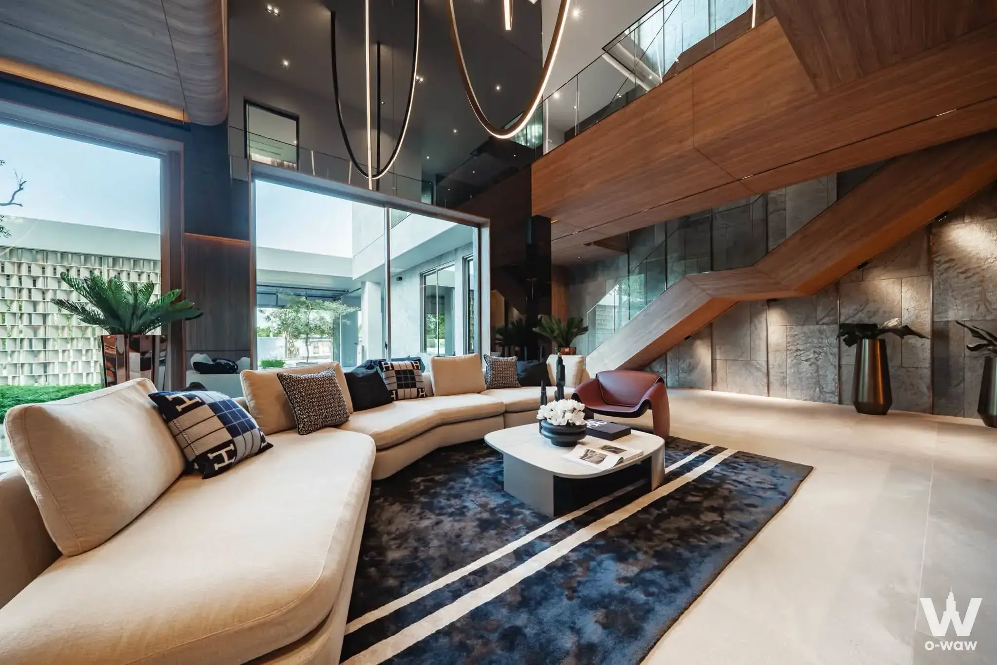 Luxury villa living room with double-height ceilings, curved beige sofa, and modern LED lighting in a 6-bed house for sale