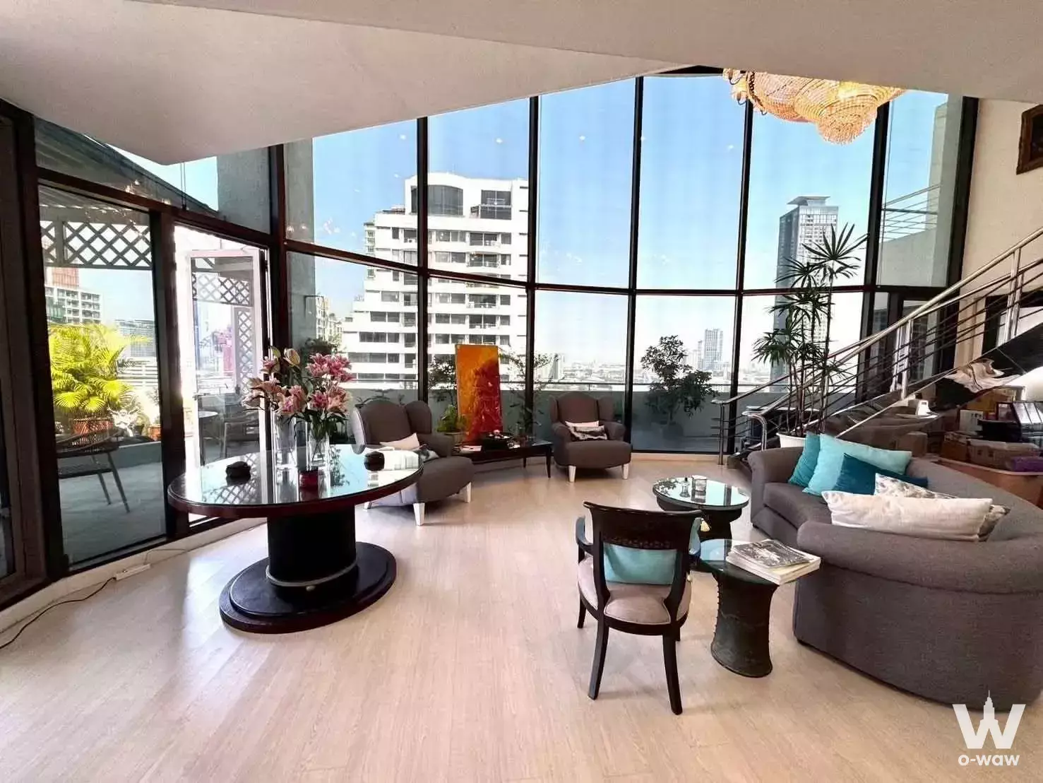 High-floor living room in Supalai Place Sukhumvit 39 with curved glass windows and panoramic city views