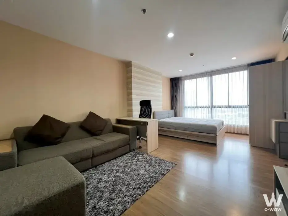 1-bed condo for sale in The Tree Interchange featuring a grey sofa and neutral tones