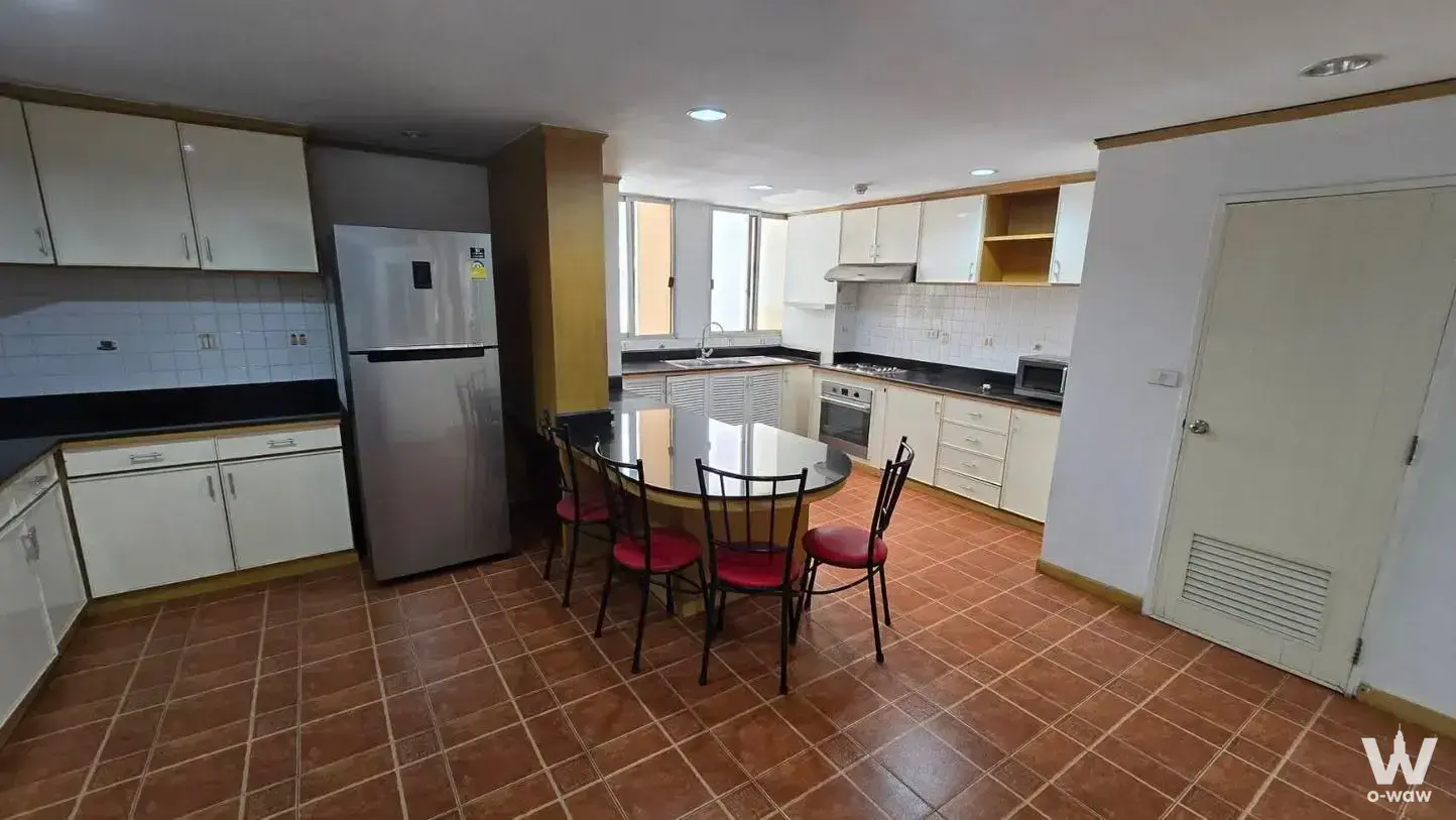 Open-plan kitchen with black countertops and stainless steel appliances in a 4-bed Tai Ping Towers condo