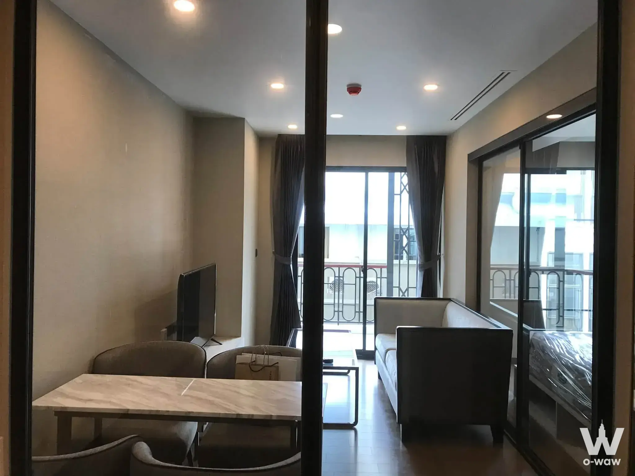 Living room with TV and balcony view in Na Vara Residence 1-bed condo