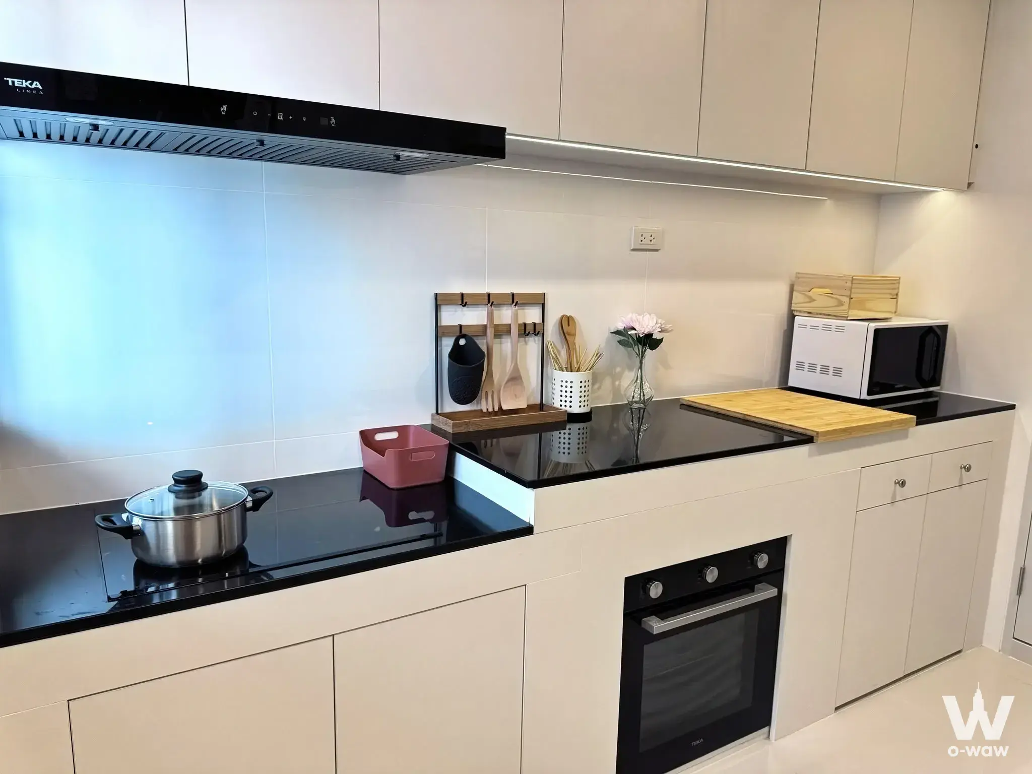 Compact galley kitchen in a 4-bed house for rent in Centro Bangna with cream cabinets and black granite countertops