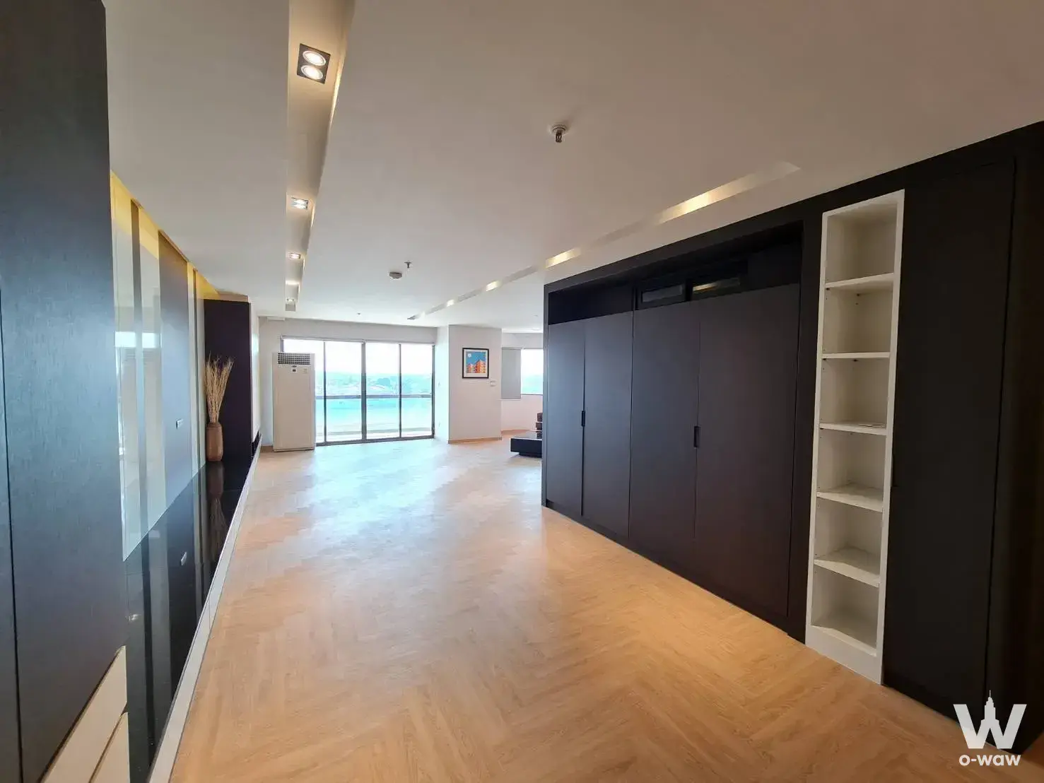 Unfurnished 3-bed condo in Salintara with herringbone oak floors and a sliding glass door framing the ocean view