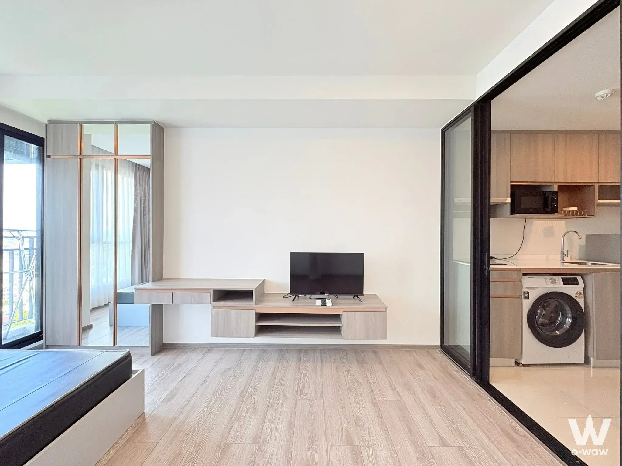 Studio living area with oak wall unit and glass partition in Knightsbridge Collage Sukhumvit 107