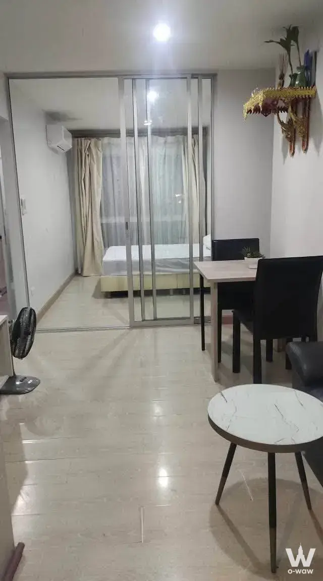 Open-plan studio with marble coffee table and glass partition separating the bedroom in this Sukhumvit 113 rental unit