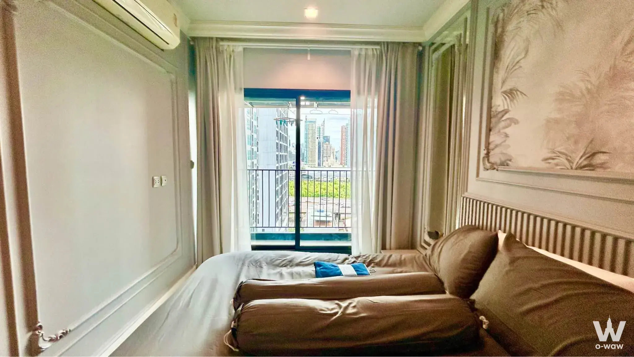 Queen bed with satin bedding and botanical mural in this 1-bed condo for rent at Life Asoke Rama 9