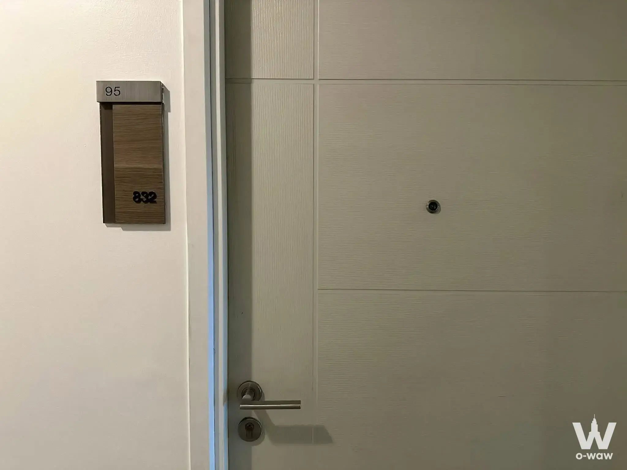 Entrance hallway of a 1-bed condo for sale in Centric Tiwanon Station with a white flat-panel door and brushed nameplate