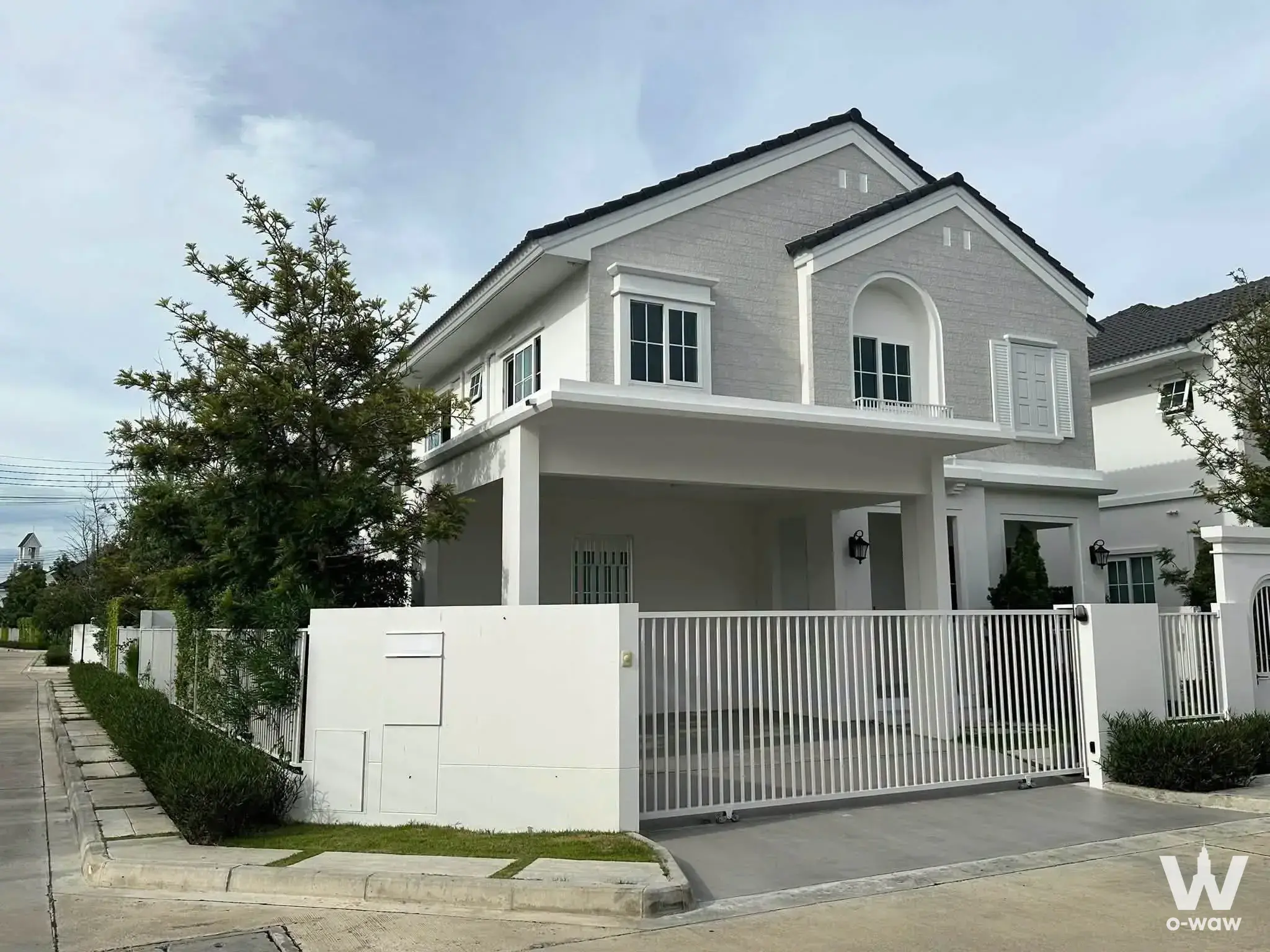 Modern two-story house for sale in Chaiyapruek Bangna with a grey brick facade and covered carport