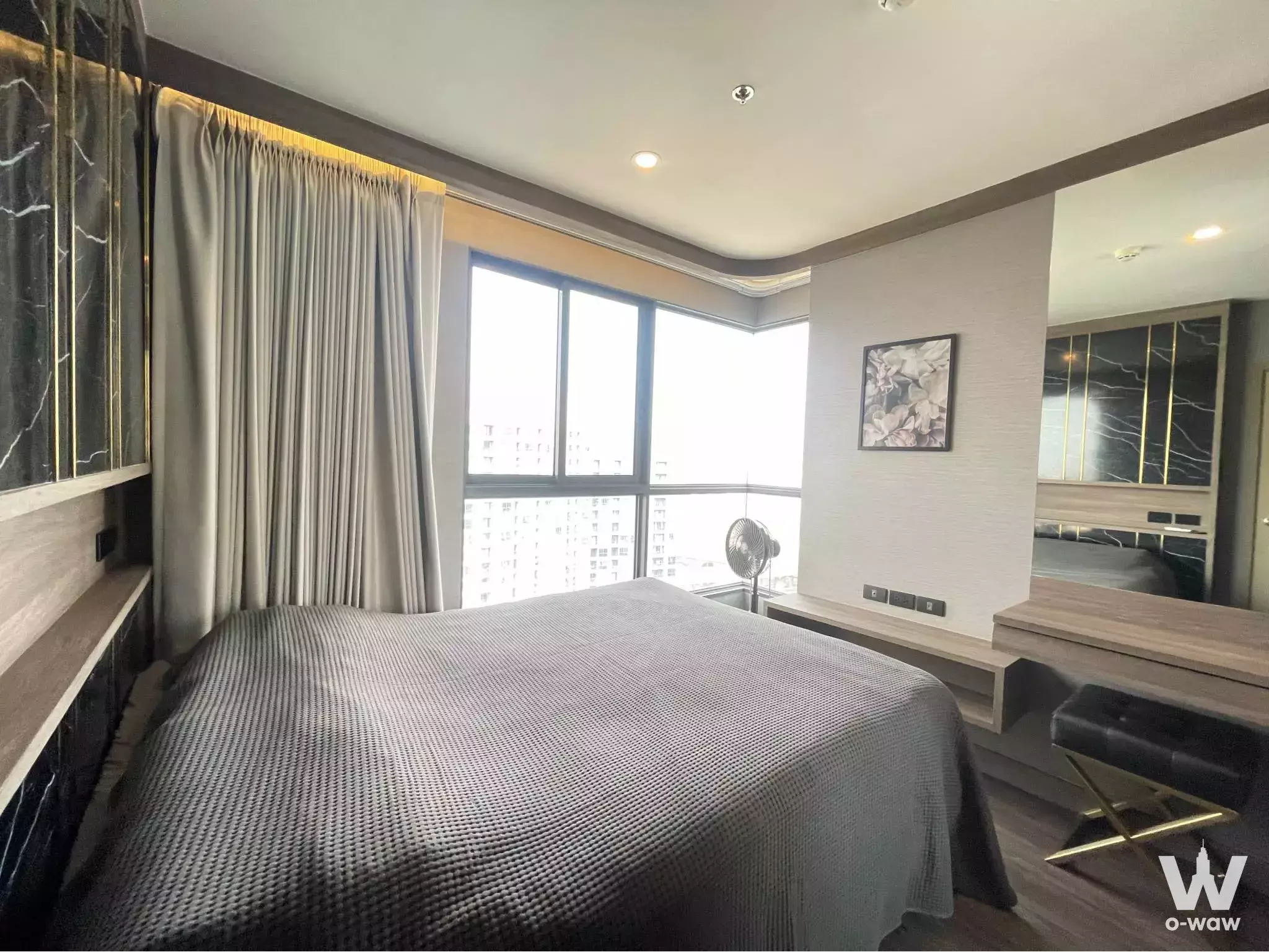 Master bedroom in Ideo O2 condo with dark marble feature wall and city view