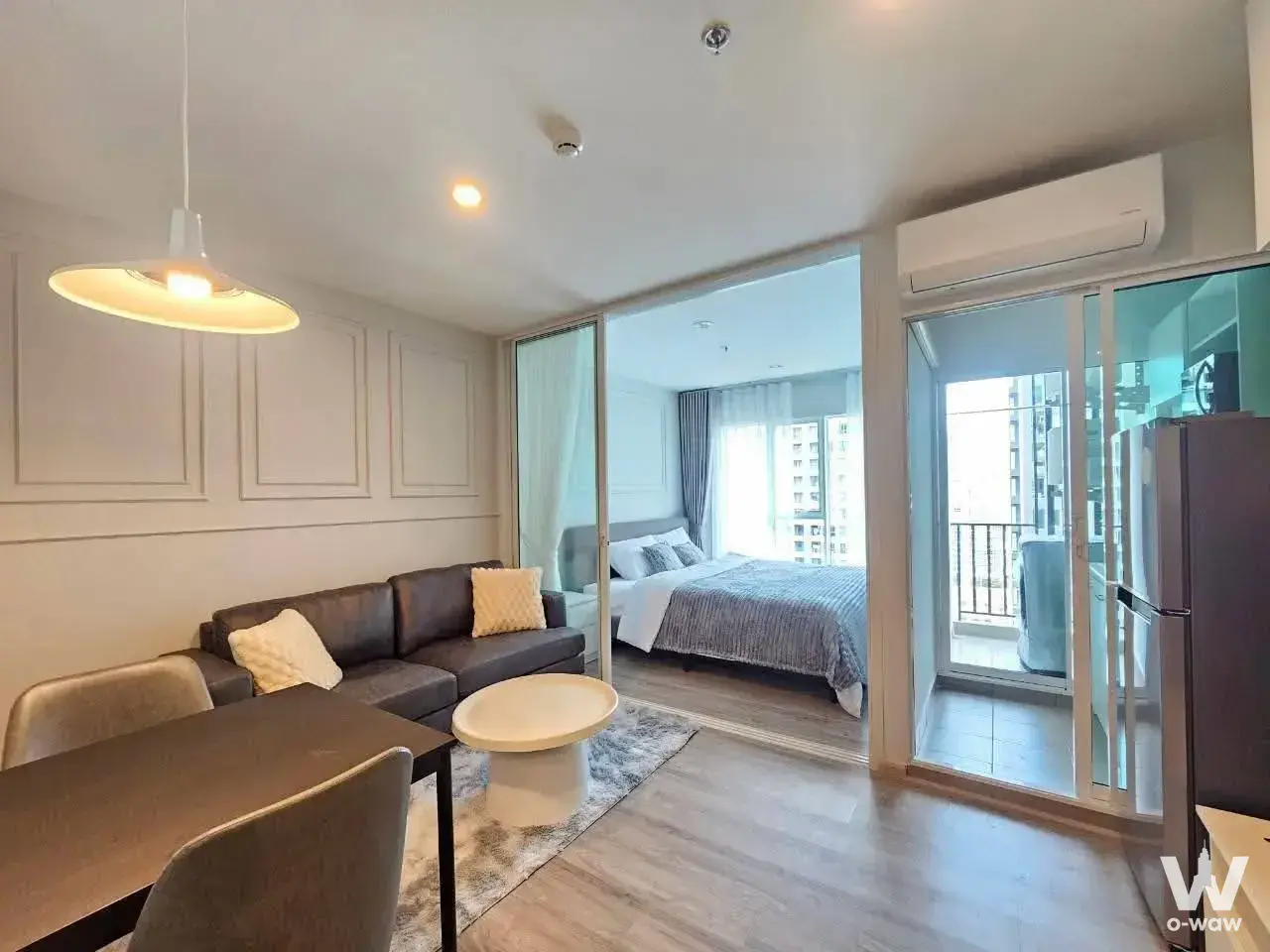 Regent Home Bangna condo interior featuring dining area, sofa, and balcony access
