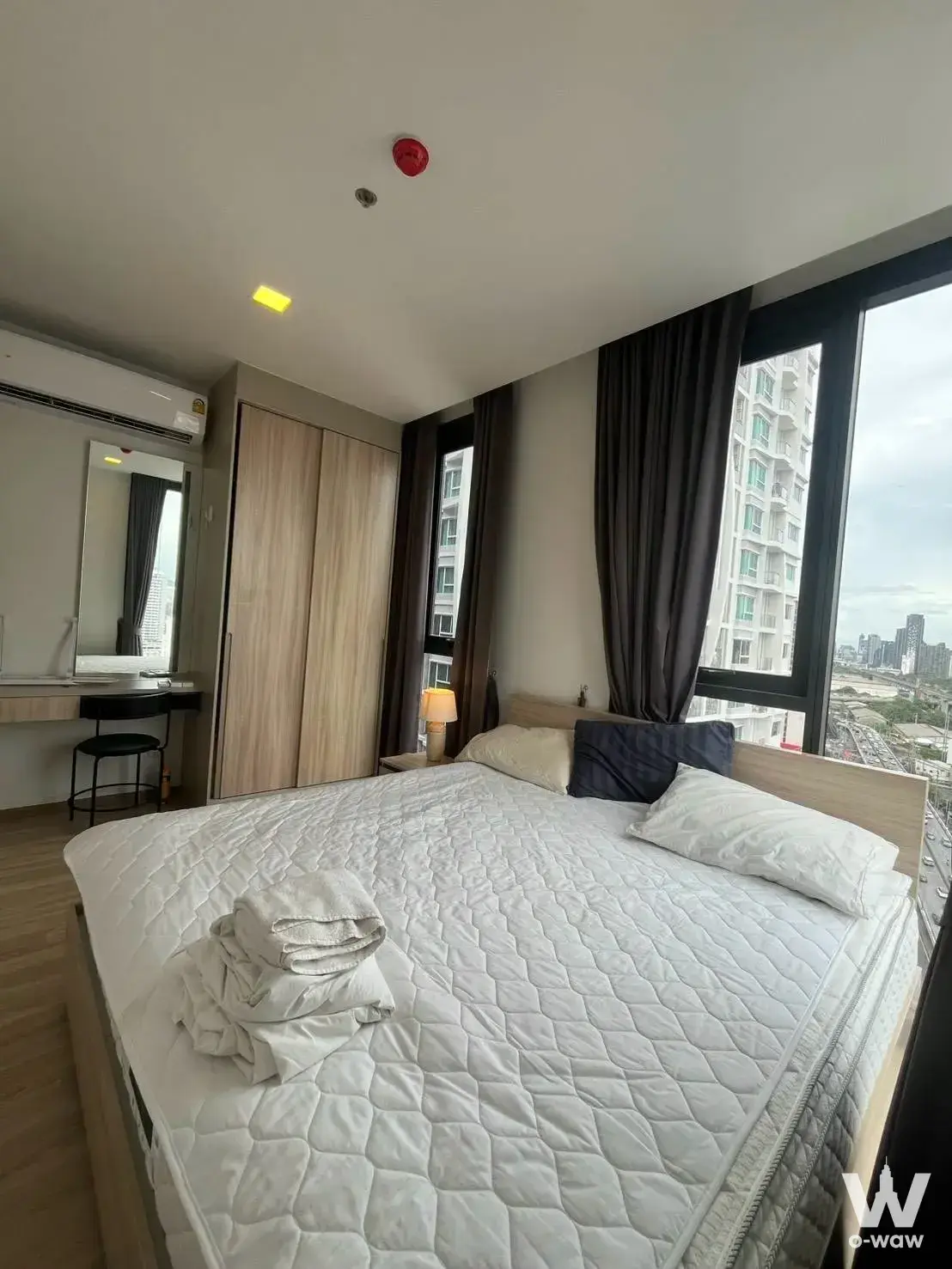 Queen bed and floor-to-ceiling windows in the bedroom of this 2-bed rental at XT Phayathai