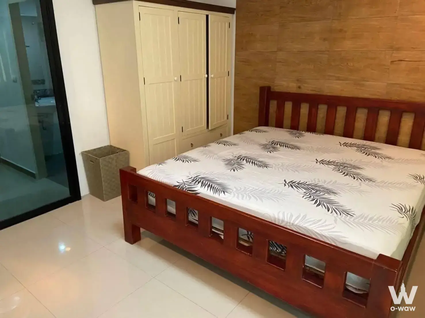 Sense of London bedroom with fern-print bedding and wood-slate wall