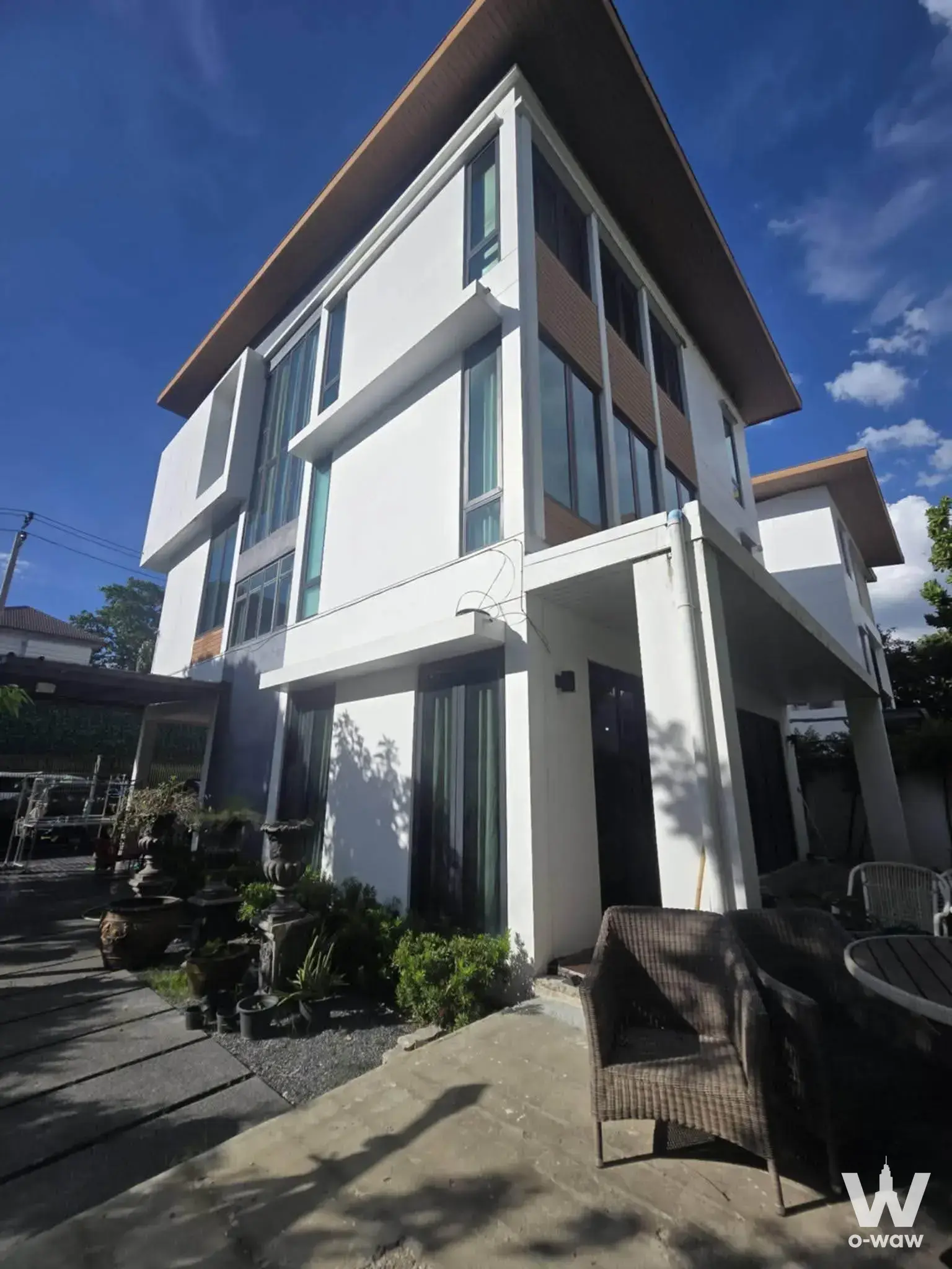 Modern 3-story detached house exterior with white stucco and tall windows at The AVA Residence 4-bed rental condo
