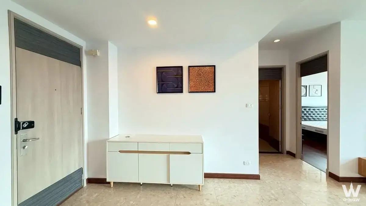 Entry foyer of the Premier Condominium 2-bed rental shows a cream sideboard and smart lock door