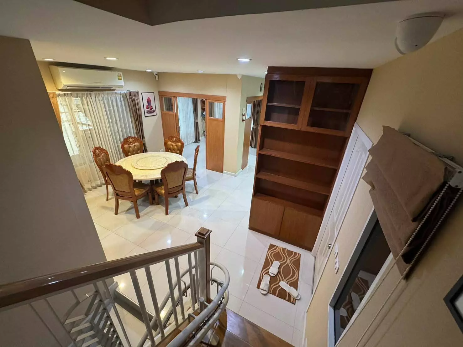 Passorn Prestige dining room with marble table, leather chairs, and staircase