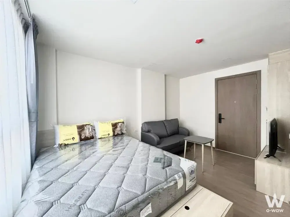 New bedroom in THE MUVE Ram 22 featuring a queen bed with grey quilted mattress and yellow pillows