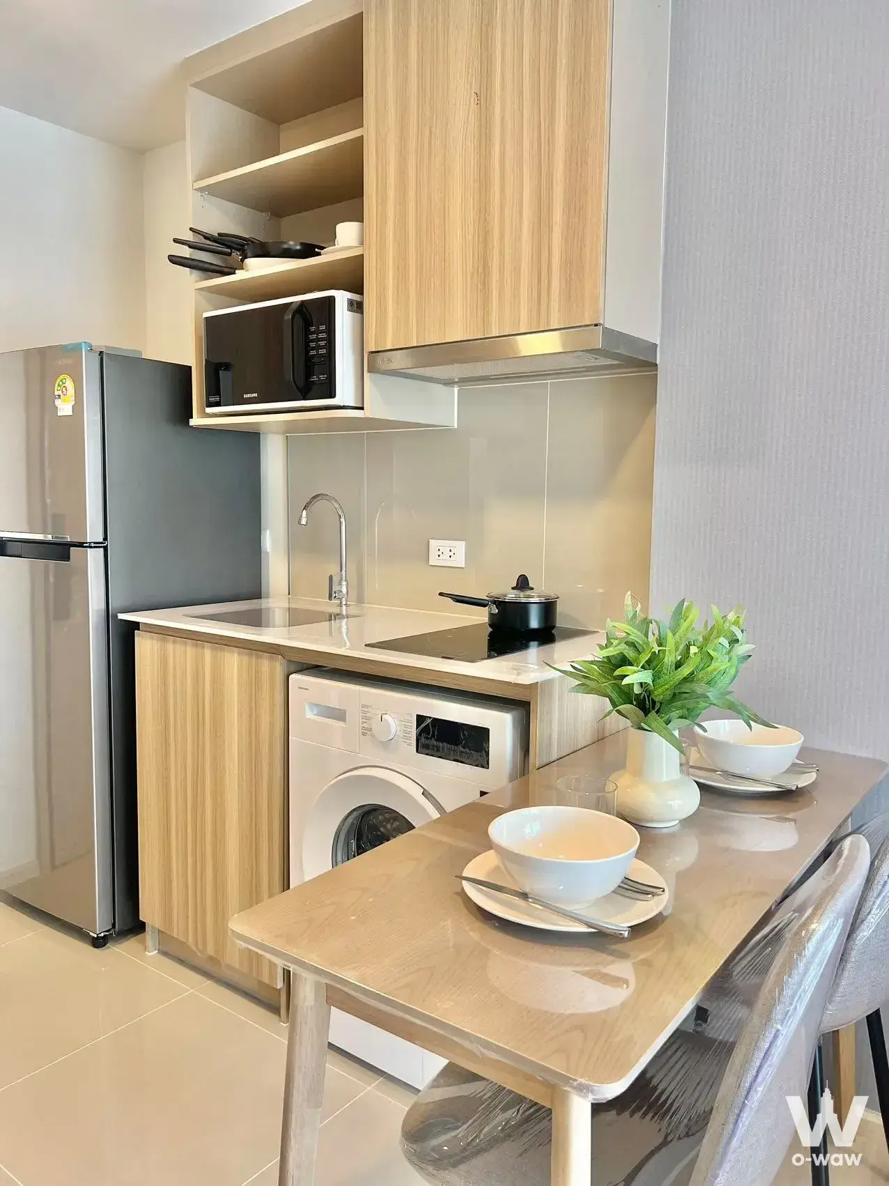 Compact kitchen and diningette with wood cabinets and modern appliances in The Base Cherngtalay