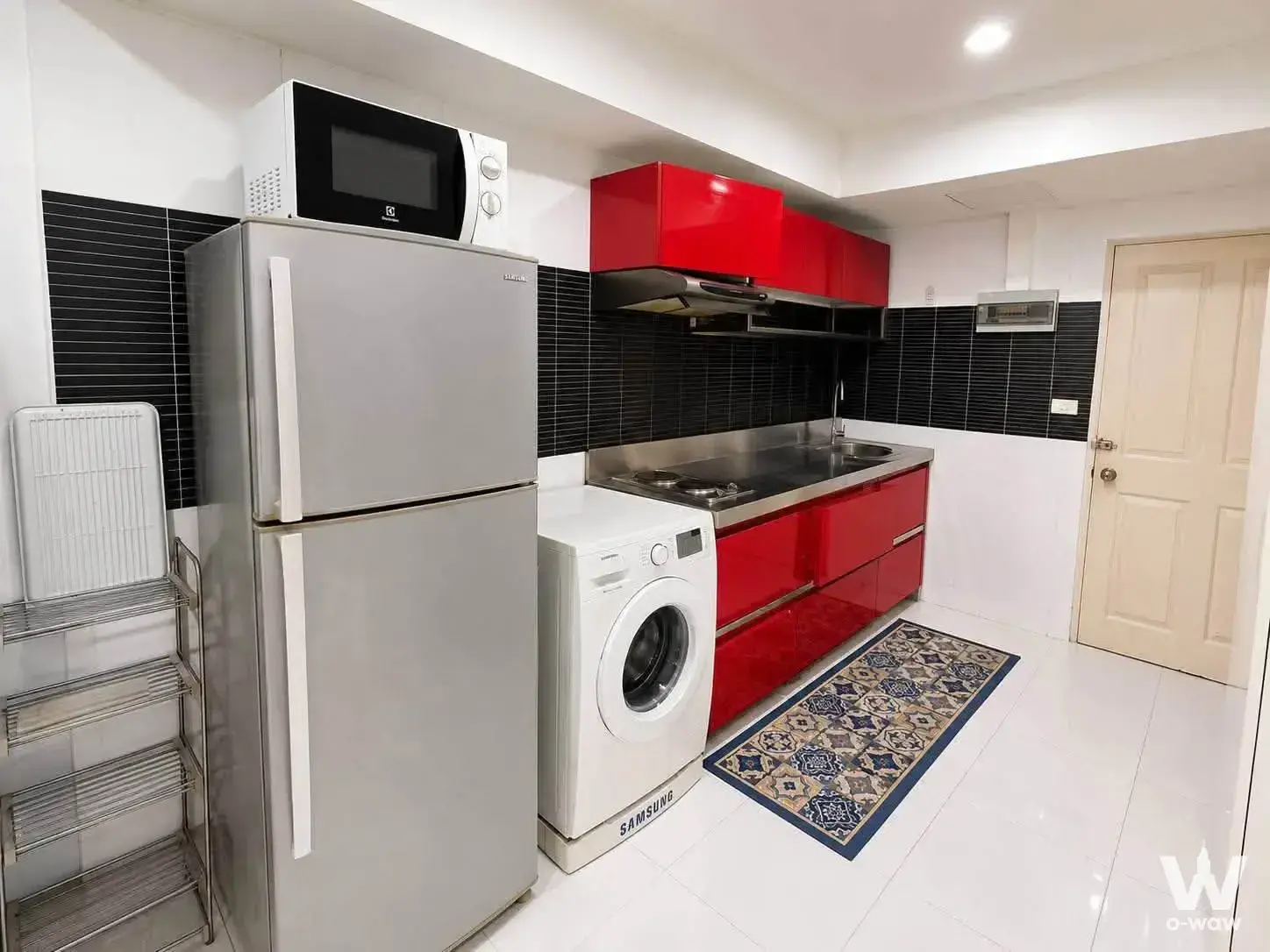 Utility kitchen in The Regent condo with red cabinets, stainless steel appliances and gas stove
