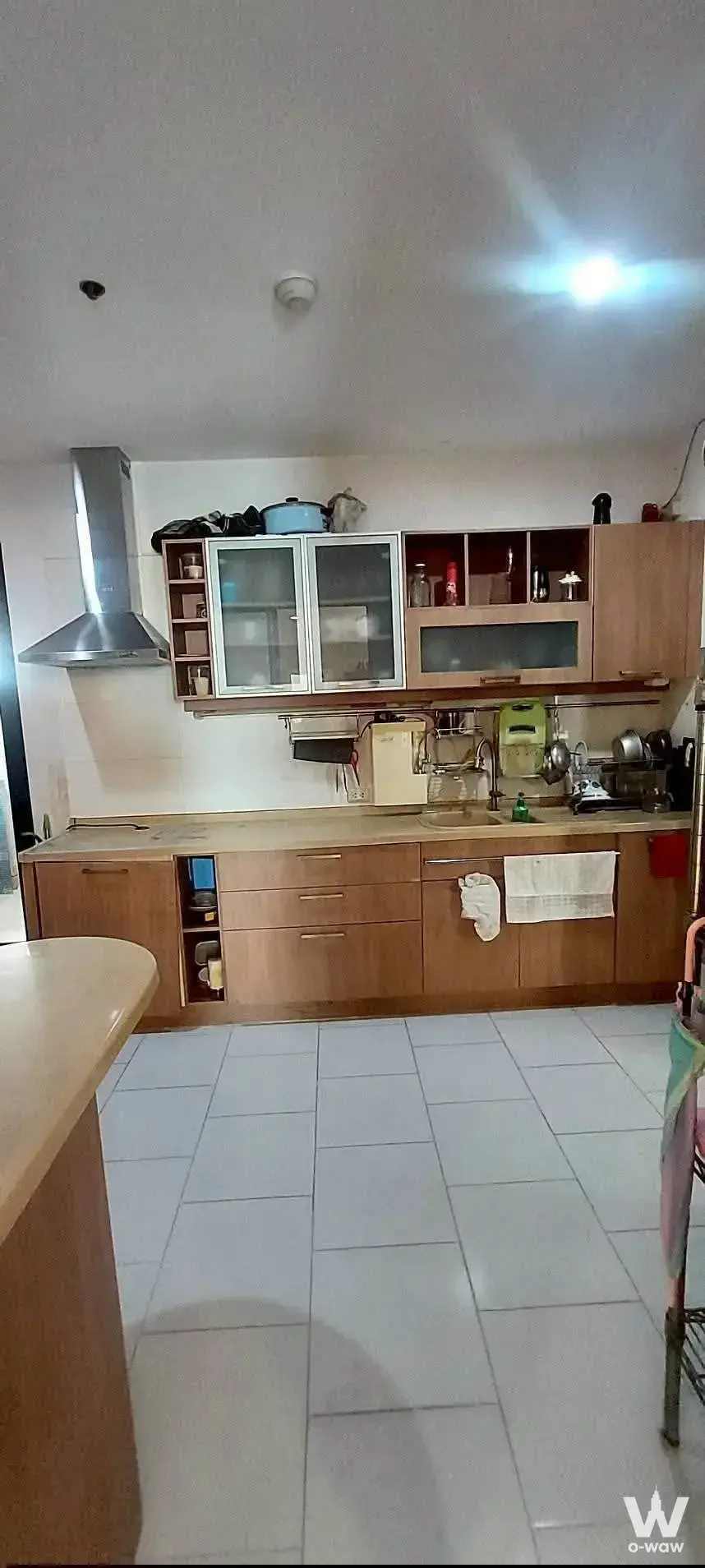 Kitchen in this Supalai Casa Riva condo has light wood cabinets and beige countertops