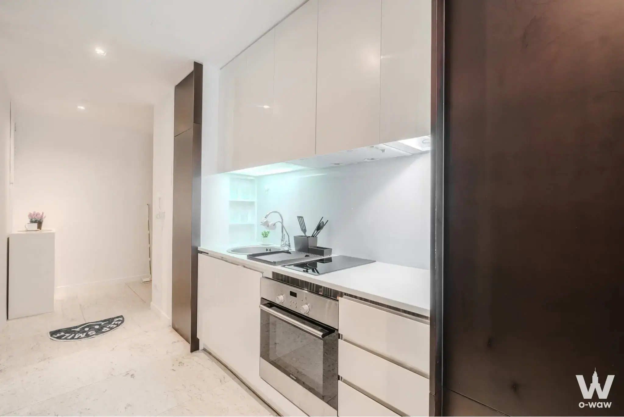 Modern 1-bed condo kitchen for sale in The Pano with glossy white handleless cabinets and quartz countertops