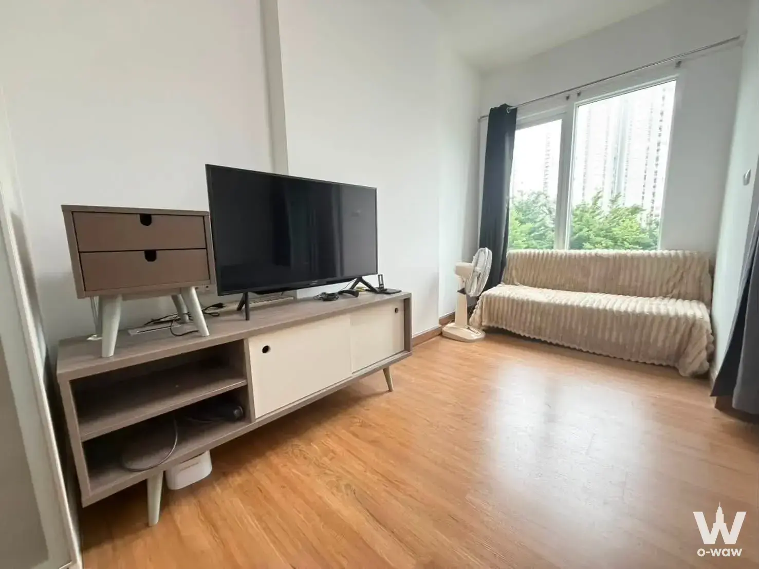 Bright living room in Chapter One Eco Ratchada-HuaiKhwang with light oak floors and a beige sofa