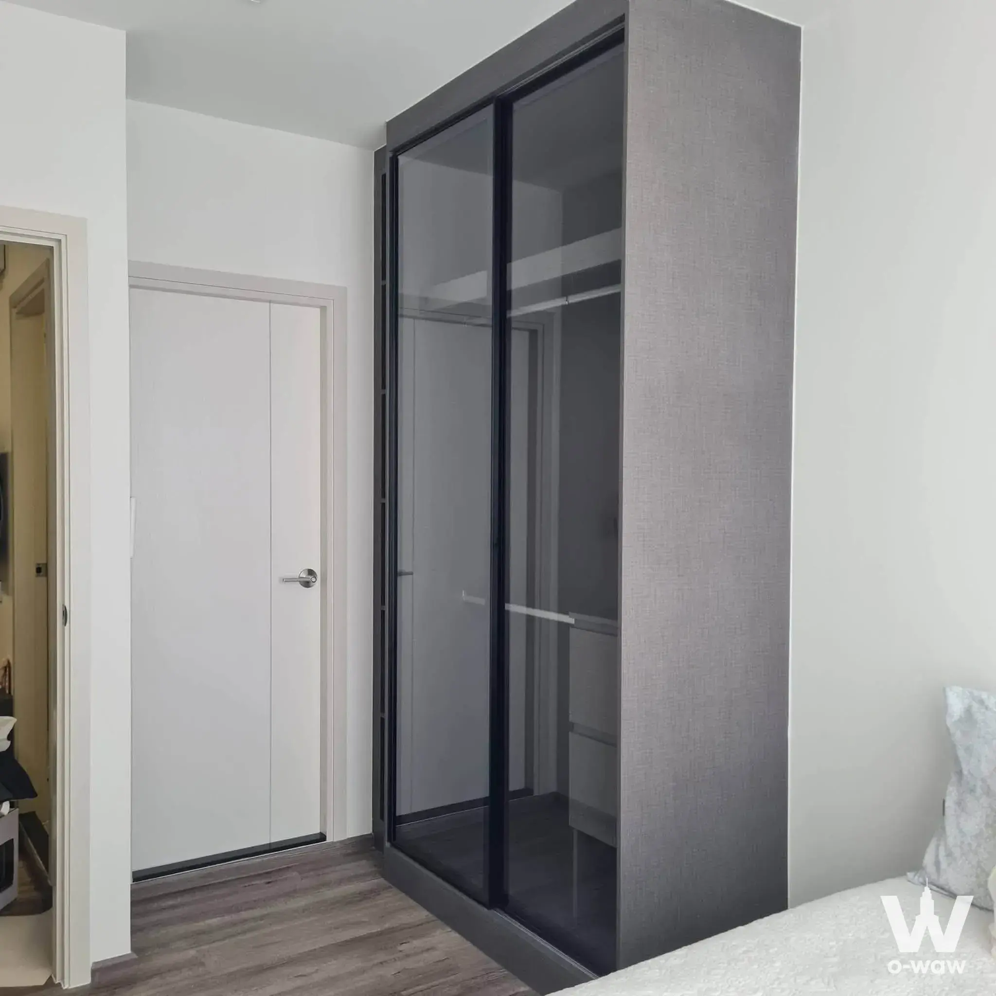 Bedroom in a Modiz Vault Kaset Sripatum condo featuring a floor-to-ceiling wardrobe with smoked glass doors