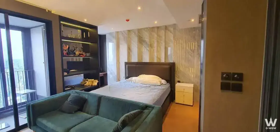 Furnished bedroom in Ashton Chula-Silom with teal sofa and marble feature wall