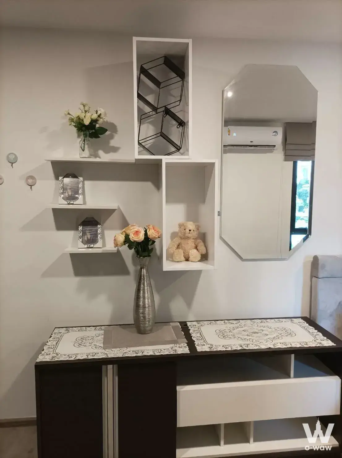 Wood console with mirror and decor in this 1-bed condo for rent at Beat Bangwa Interchange