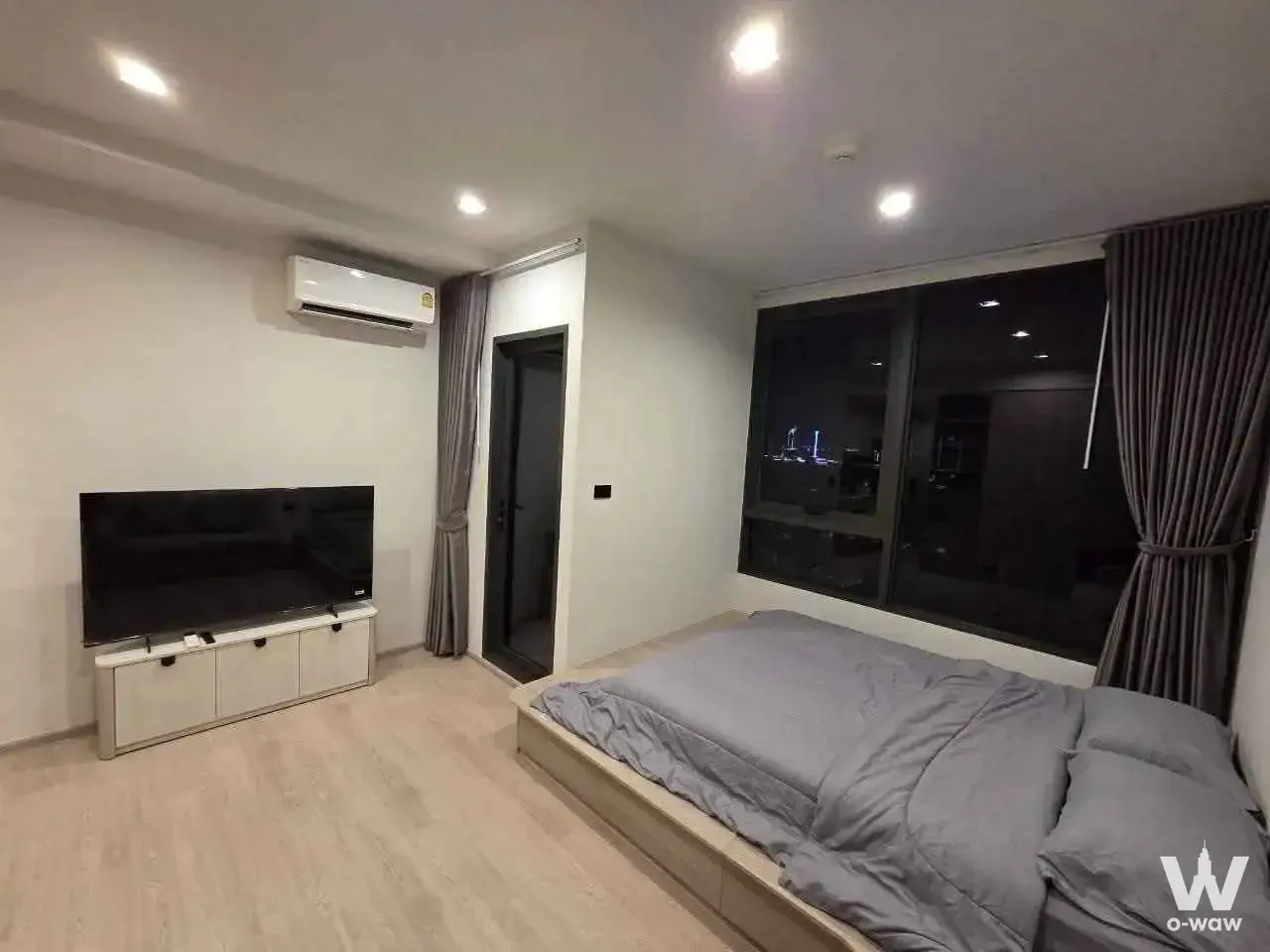 Reference Sathorn-Wongwianyai 1-bed condo rental bedroom has a city night view and a low platform bed with drawers