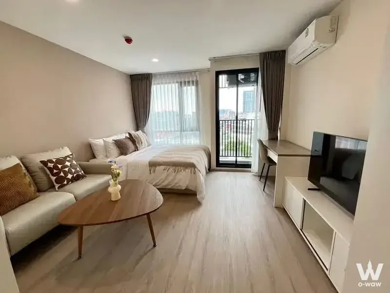 Furnished studio in Brompton Pet Friendly Samrong showing sofa, bed, and high-floor city view