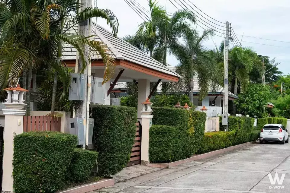 Single-story house exterior for rent at Baan Dusit Pattaya View with white walls, terracotta trim, and manicured hedges