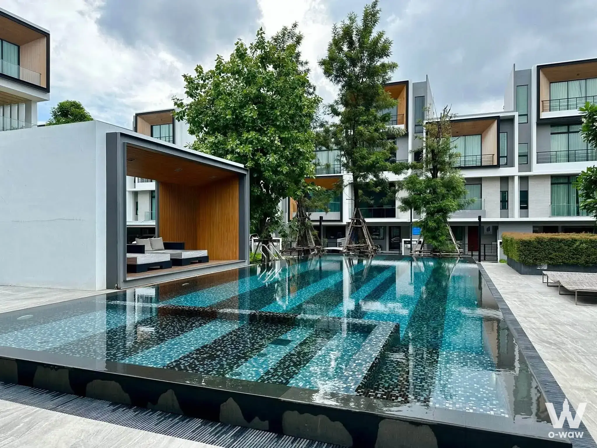 Resort-style infinity pool at Nirvana Define Rama 9 townhouse with lounge daybeds and tropical greenery