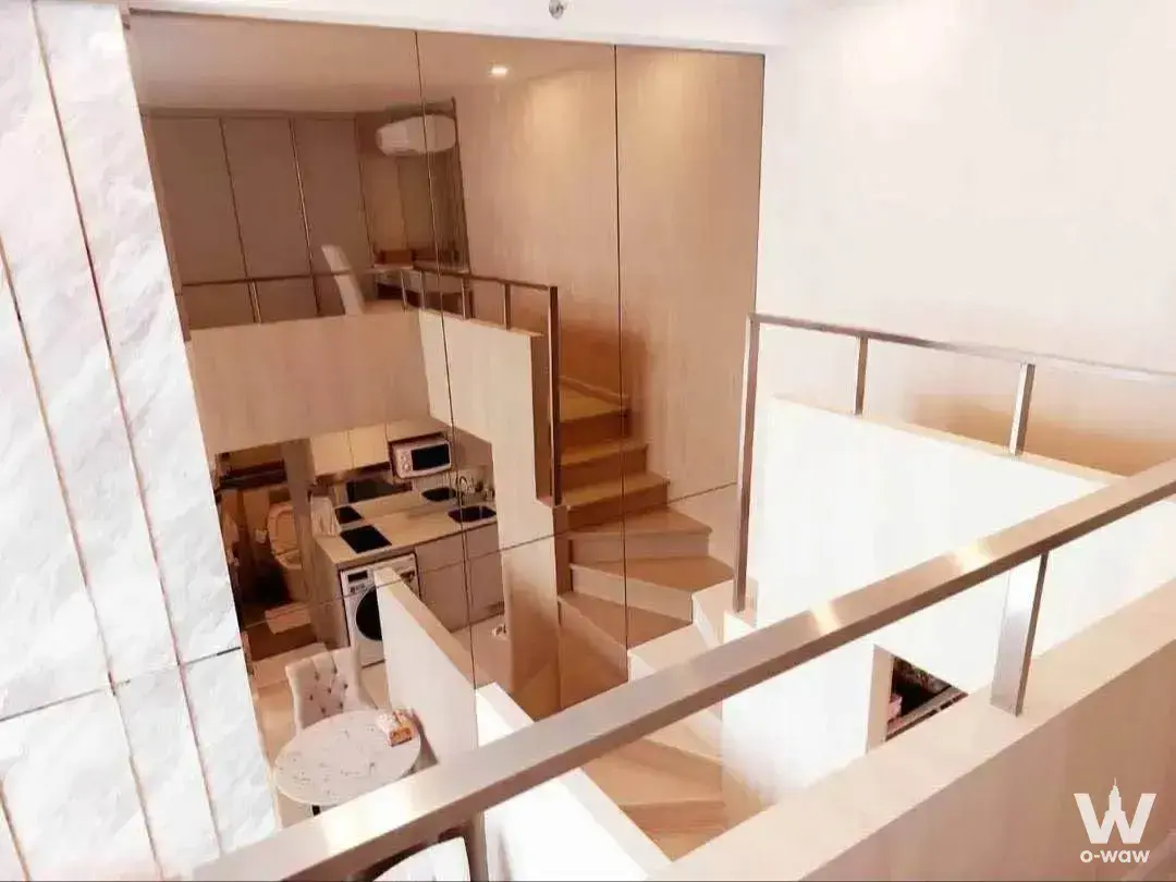 2-bed condo for sale at KnightsBridge Prime Sathon featuring light wood stairs, marble column, and mirrored walls