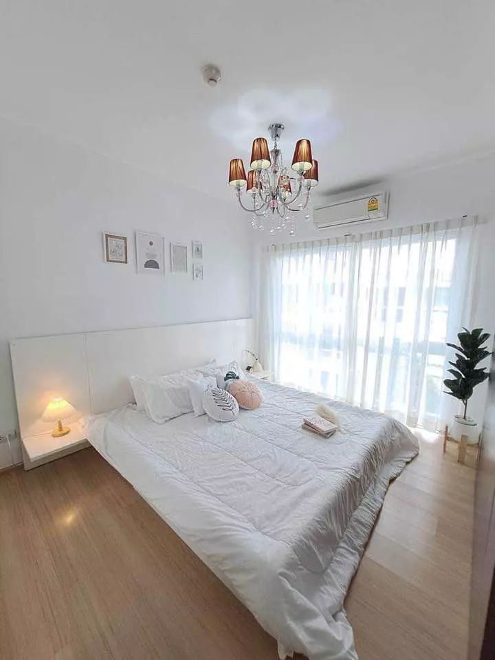 Bedroom in A space Sukhumvit 77 rental featuring white bedding and a crystal chandelier