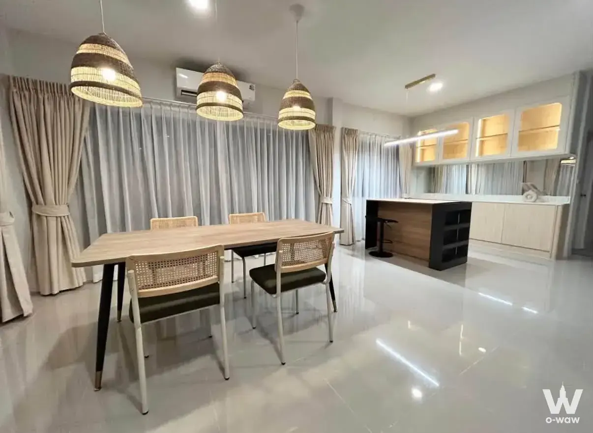 Open-plan dining area in 3-bed townhouse Grande Pleno Sukhumvit-Bangna with rattan lights