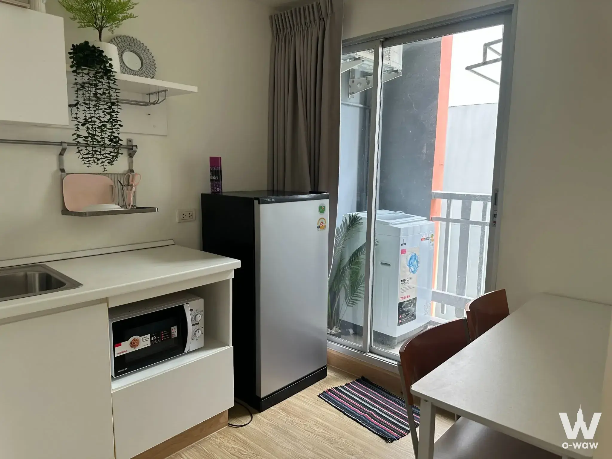 Plum Condo Ladprao 101 studio featuring compact kitchenette, balcony access, and tidy furnished space